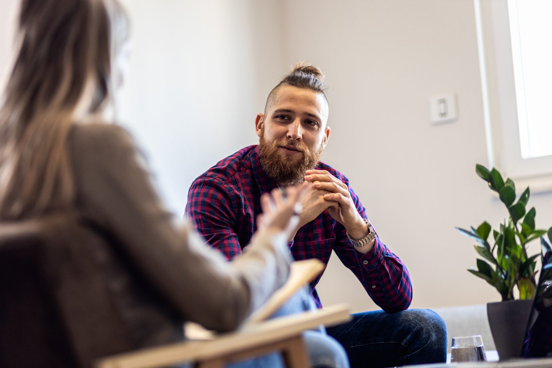 A man in a checked shirt talking to a woman